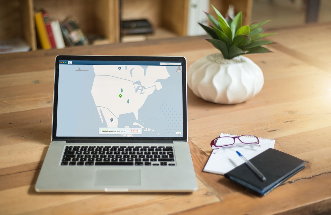 The Art of Drawing Readers In: Your attractive post title goes here A laptop displaying VPN software sits on a wooden desk with a notepad and plant offering a secure workspace vibe.